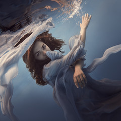 Portrait of a girl in a blue dress under water
