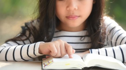 cute little asian girl in reading bible. hands holding on a holy bible. little child girl hands folded in prayer on a holy Bible for faith,spirituality and religion concept.