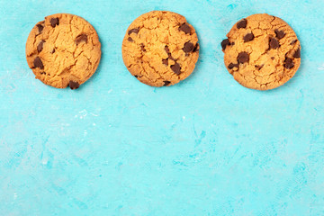 Chocolate chip cookies, shot from above on a blue background with a place for text