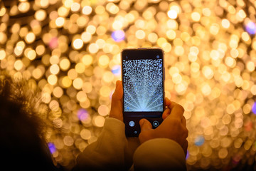 Tourists taking pictures with mobile phones in The tunnel is decorated with millions of lights and...