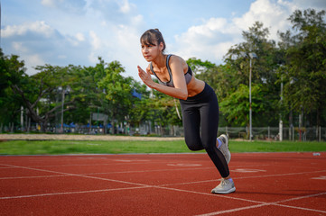 strong and healthy body of young woman sporty in the way of start practice running in sport stadium, concentrate to the winner ahead.