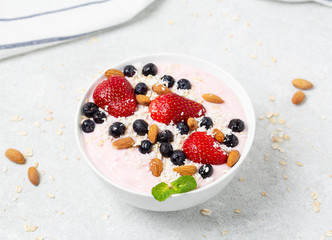 Healthy Breakfast Food. Granola with yogurt, blueberries and strawberry on gray concrete table background. 