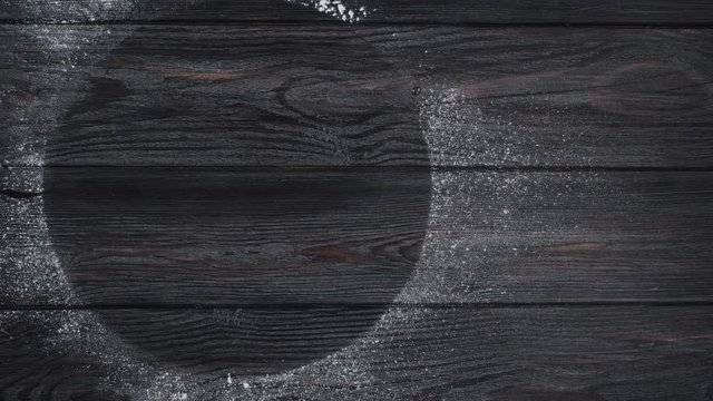 Background. Wooden gray boards sprinkled with flour with an empty circle inside. Top view. Camera movement from right to left.4k video.