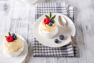 Delicious Pavlova cake with whipped cream and fresh raspberry and blueberry. Selective focus