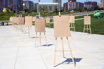 Pair of Easel with blank canvas . Blank art board and realistic wooden easel outdoors. Drawing board easel blank exhibition at city street . Wooden easel with blank canvas .