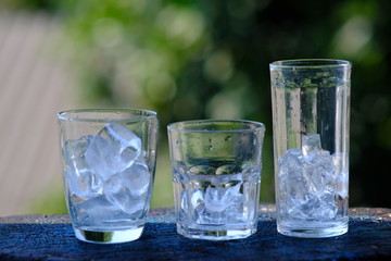 glass of water with ice on bokeh background