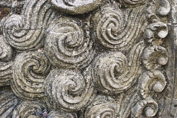 Closeup detail of carved stone curls abstract background pattern