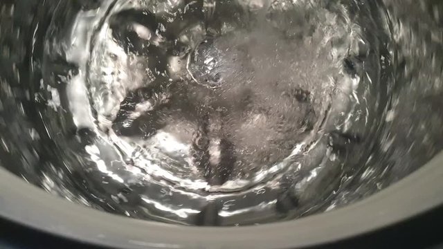 Stainless steel washing machine drum turning spin cycle, futuristic industrial look of modern machinery