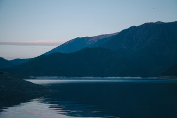 the concept of boating, recreation, travel - splashes of blue water in the river, mountains, sky. Copy space