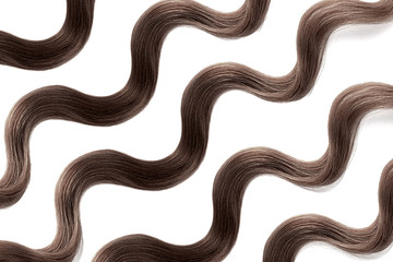 Brown hair on white, isolated. Thin curly threads as background