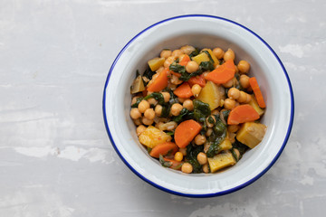 chick-pea with carrot and spinach on white bowl on ceramic backgeound
