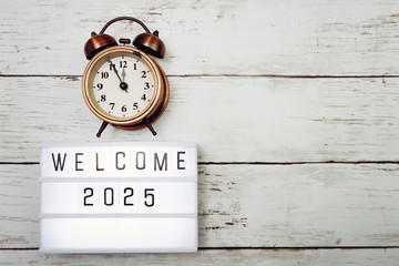 Welcome 2025 text in light box with space copy on wooden background