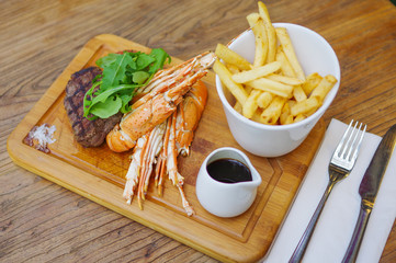 Surf and turf lobster&steak with french fries on wood tray