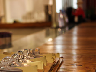Naklejka na ściany i meble Restaurant paper menus and metal hinge clips on wooden table near bar counter