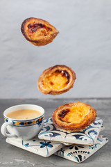 typical portuguese egg tart pastel de nata with cup of coffee on ceramic background