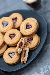 cookies with hearts on dark plate on ceramic background