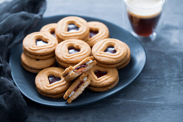 cookies with hearts on dark plate on ceramic background