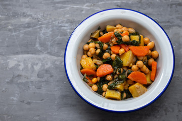 chick-pea with carrot and spinach on white bowl on ceramic background