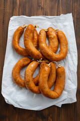 portuguese smoked sausages alheira on paper wooden background