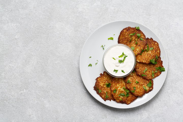 Crispy potato pancakes with yogurt sauce. Potato pancakes fried in butter. Stack of potato fritters