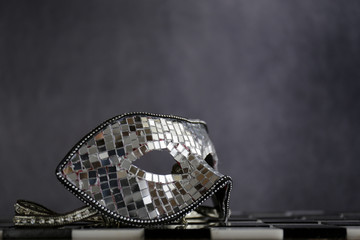 Maschera d'argento sopra la scacchiera bianca e nera con coriandoli  e cristalli