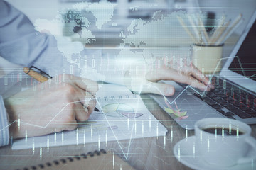 Multi exposure of stock market graph with man working on laptop on background. Concept of financial analysis.