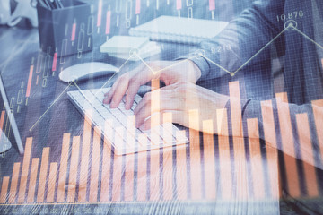 Multi exposure of financial graph with man works in office on background. Concept of analysis.