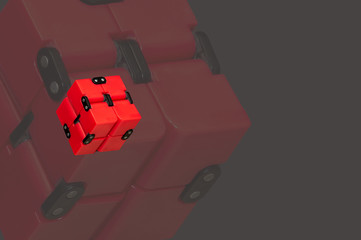 Double exposure of a red 3d cube flying in the air on a grey isolated background.The concept of object levitation. Macro mode.Copy space. Logical thinking. Anti-stress toys.