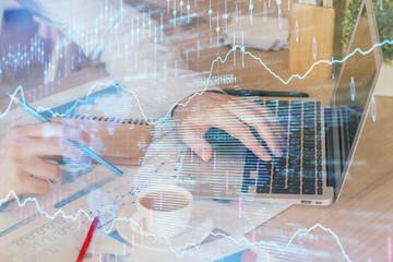Forex graph with businessman working on computer in office on background. Concept of hardworking....