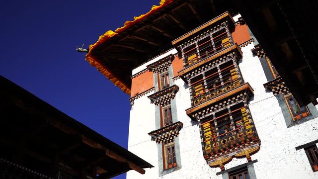 Temple Dzong and religious prayer flags in valley, Bhutan