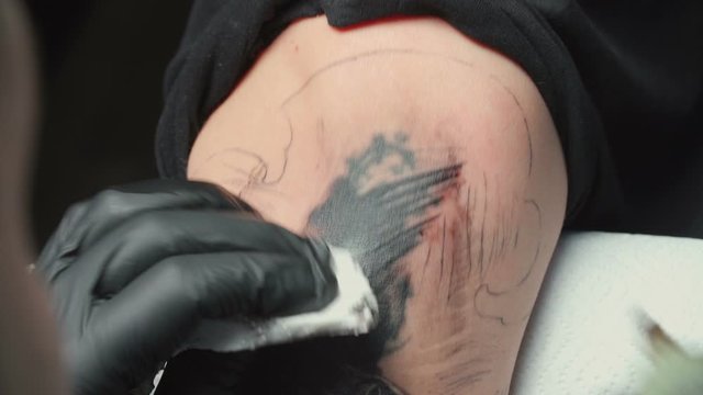 Video of man tattooist getting tattoo of python for woman