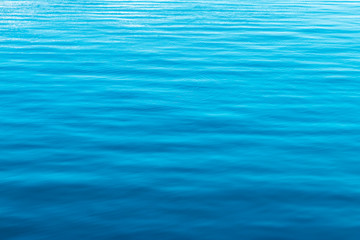 The surface of the blue calm sea with light ripples.