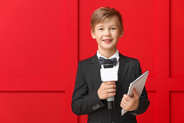 Little journalist with microphone on color background