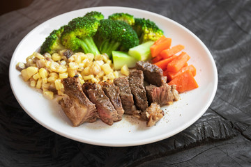 Grilled beef slice with sweet corn, broccoli and carrot on white plate. Easy and delicious meal at home.