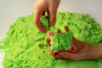 Kinetic sand. A child plays with kinetic sand. Fine motor skills, creativity, games.