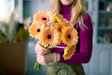  Bouquet of beautiful bright gerbera flowers in hand. Floral shop concept 