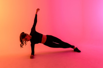 Sports girl on a bright color background does exercises. 