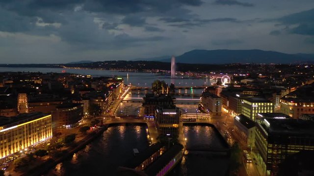 night illuminated flight over geneva city center lakeside traffic river bay aerial panorama 4k switzerland