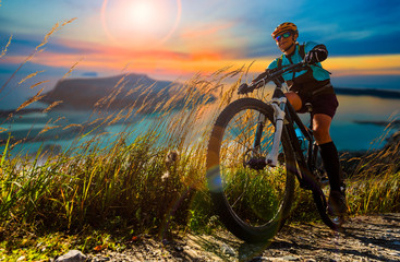 Cycling woman and man riding on bikes in Dolomites mountains andscape. Couple cycling MTB enduro...