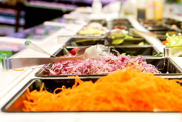 Freshly cut vegetables are lined up in a tray for sale as a vegetable salad in the supermarket.