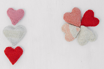 Hand made knitted heart on white wooden background. Valentine's day card with woolen heart and free space. Romantic sign.Hand made knitted heart on white wooden background. Valentine's day card with w