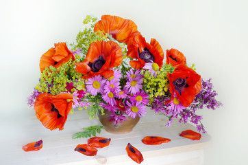 Bouquet with red poppies in a vase isolated on white background