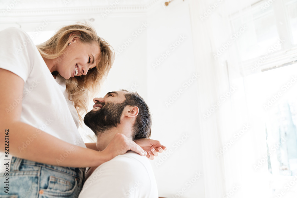 Wall mural loving couple indoors at home hugging.