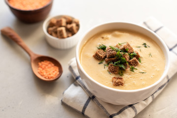 Tomato soup in a black bowl on grey stone background. Top view. Copy space.