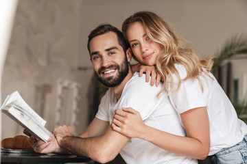 Optimistic loving couple reading book.
