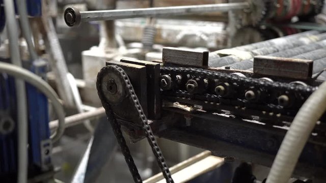 Greasy mechanism, black metallic gears and cogs at work. Closeup of rotating gears and chains on industry machine conveyor roller. Engine gears wheels.