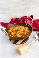 Homemade Indian spicy Potato and tomato curry also known as aloo tamatar ki sabji in hindi, served...