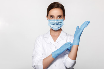 Young woman doctor in white uniform wearing mask and gloves. Coronavirus. 2019-nCoV.