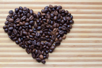 Heart shape made from coffee beans on wooden background. Valentine’s day.