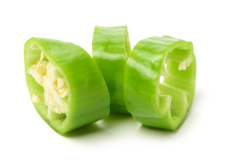 Green chili pepper cut in pieces on a white background